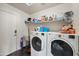 Practical laundry room equipped with modern washer, dryer and ample storage shelving at 11840 N 59Th Ln, Glendale, AZ 85304