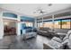This well-lit living room showcases a comfortable gray sofa, TV, and ample natural light from large windows at 11840 N 59Th Ln, Glendale, AZ 85304