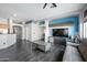 Bright, open-concept living area with a TV, gray sofa, modern flooring, and neutral wall paint at 11840 N 59Th Ln, Glendale, AZ 85304