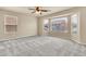 Bright bedroom with plush carpeting, a ceiling fan, and a large bay window offering neighborhood views at 121 W Hackberry Dr, Chandler, AZ 85248