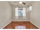 Bedroom with hardwood flooring, a large window with sheer curtains, and neutral colored walls at 121 W Hackberry Dr, Chandler, AZ 85248