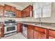 Well-equipped kitchen featuring stainless steel appliances, granite countertops, and dark wood cabinetry at 121 W Hackberry Dr, Chandler, AZ 85248