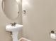 Powder room with a pedestal sink, a round mirror, neutral colors, and tile flooring at 121 W Hackberry Dr, Chandler, AZ 85248