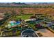 Aerial view of community featuring a pool, tennis courts, and clubhouse with surrounding desert landscape at 12780 W Desert Vista Trl, Peoria, AZ 85383
