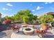 Beautiful backyard has a built in firepit with comfortable seating and mature landscaping at 12780 W Desert Vista Trl, Peoria, AZ 85383