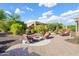 Landscaped backyard features a built-in firepit surrounded by seating at 12780 W Desert Vista Trl, Peoria, AZ 85383