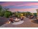 Well-lit backyard showcasing the stone waterfall feature and outdoor seating areas, perfect for evening gatherings at 12780 W Desert Vista Trl, Peoria, AZ 85383