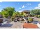 Tranquil backyard with a beautiful waterfall feature, lounge chairs, and lush landscaping at 12780 W Desert Vista Trl, Peoria, AZ 85383