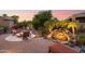 Backyard with fire pit, rock waterfall, and lush landscaping illuminated at twilight for a cozy ambiance at 12780 W Desert Vista Trl, Peoria, AZ 85383