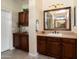 Elegantly designed bathroom showcasing dark wood cabinetry, granite countertops, and tiled flooring at 12780 W Desert Vista Trl, Peoria, AZ 85383
