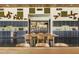 Long kitchen and seating area featuring gray cabinets, stainless appliances, and artistic decor at 12780 W Desert Vista Trl, Peoria, AZ 85383