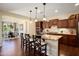 A gourmet kitchen featuring granite countertops, dark wood cabinets, and stainless steel appliances, with an adjacent dining area at 12780 W Desert Vista Trl, Peoria, AZ 85383