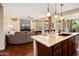 Open-concept kitchen with granite island flowing into the living room, promoting seamless entertaining at 12780 W Desert Vista Trl, Peoria, AZ 85383