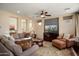 Spacious living room with plush sofa, TV, and large windows overlooking the backyard at 12780 W Desert Vista Trl, Peoria, AZ 85383