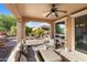 Covered patio has comfortable seating with a view of the landscaped backyard at 12780 W Desert Vista Trl, Peoria, AZ 85383