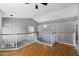 Bright second-floor hallway featuring hardwood floors, a railing overlooking the stairwell, and neutral decor at 1381 N Alexis Dr, Gilbert, AZ 85234