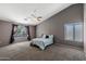 Spacious main bedroom with carpet, neutral paint, a ceiling fan, and large windows with dark curtains at 1381 N Alexis Dr, Gilbert, AZ 85234