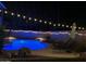 Backyard pool area lit up at night with outdoor seating at 1381 N Alexis Dr, Gilbert, AZ 85234