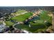 Aerial view showcases lush golf course with mature trees, a tranquil pond and well maintained landscaping in this community at 15635 W Hackamore Dr, Surprise, AZ 85387