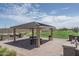Covered picnic area with benches, tables, grill, and lush green landscaping, perfect for outdoor gatherings and relaxation at 15784 W Soft Wind Dr, Surprise, AZ 85387