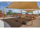 Playground featuring sunshades, slides, climbing structures, picnic tables, and a wood chip ground cover at 15784 W Soft Wind Dr, Surprise, AZ 85387