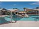 Modern pool area with splash pad and tables at 15784 W Soft Wind Dr, Surprise, AZ 85387