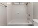 Bright bathroom features a shower and tub combination with white tile surround at 1617 W Vineyard Rd, Phoenix, AZ 85041