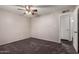 Spacious bedroom featuring neutral carpet, ceiling fan, and adjacent bathroom entrance at 1617 W Vineyard Rd, Phoenix, AZ 85041