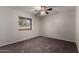 Cozy bedroom with neutral carpet, ceiling fan, and a bright window at 1617 W Vineyard Rd, Phoenix, AZ 85041