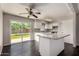 Bright kitchen featuring white cabinets, granite countertops, an island, and sliding glass doors to the backyard at 1617 W Vineyard Rd, Phoenix, AZ 85041