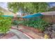 Backyard featuring a charming garden with vibrant plants, stone accents, and a tranquil shaded area at 17374 W Adams St, Goodyear, AZ 85338