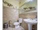 Bathroom features a pedestal sink, tile walls, and decorative elements at 17374 W Adams St, Goodyear, AZ 85338