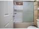 Bathroom featuring a shower with a sliding glass door and white tiled walls at 17374 W Adams St, Goodyear, AZ 85338