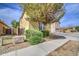 Side view of stucco house, showing sidewalk, landscaping and a tree on a sunny day at 17374 W Adams St, Goodyear, AZ 85338