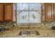 Close up of granite countertops, stainless sink, and wood cabinets in kitchen at 17374 W Adams St, Goodyear, AZ 85338