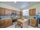 Charming kitchen with wood cabinetry, granite countertops, and stainless-steel appliances at 17374 W Adams St, Goodyear, AZ 85338