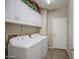 Functional laundry room equipped with a washer, dryer, and ample storage cabinets at 17374 W Adams St, Goodyear, AZ 85338