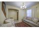 Cozy living room featuring tile floors, chandelier, neutral sofa, and two accent chairs at 17374 W Adams St, Goodyear, AZ 85338