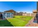 Backyard featuring green grass, shed, brick border, firepit, and block fencing at 18008 W Tina Ln, Surprise, AZ 85387