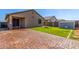 The backyard is a brick patio with an adjacent green grass yard, block walls, and a small shed at 18008 W Tina Ln, Surprise, AZ 85387