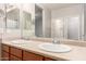 Bathroom close up featuring a large mirror with double sinks and wood-look cabinetry at 18008 W Tina Ln, Surprise, AZ 85387