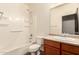 Clean bathroom features a tub and shower combo with cherry cabinets and a large mirror at 18008 W Tina Ln, Surprise, AZ 85387