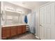Bright bathroom featuring a double vanity, shower with stylish curtain, and wood-look flooring at 18008 W Tina Ln, Surprise, AZ 85387
