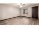 Spacious bedroom featuring wood-look floors, a ceiling fan, and a large window for natural light at 18008 W Tina Ln, Surprise, AZ 85387