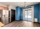 Bright dining area with blue accent wall, hardwood floors, sliding glass doors to patio, and modern light fixture at 18008 W Tina Ln, Surprise, AZ 85387