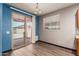 The dining area features wood floors, neutral walls, a window with blinds, and sliding glass doors to the patio at 18008 W Tina Ln, Surprise, AZ 85387