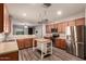 Bright, open kitchen featuring stainless steel appliances, a center island and wood cabinets at 18008 W Tina Ln, Surprise, AZ 85387