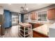 Open kitchen and dining area with stainless appliances, wood cabinets, center island, and wood floors at 18008 W Tina Ln, Surprise, AZ 85387