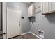 Practical laundry room includes cabinets, appliances, and direct exterior access at 18008 W Tina Ln, Surprise, AZ 85387