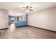 Open-concept living room with wood-look floors, a ceiling fan, and easy access to the kitchen at 18008 W Tina Ln, Surprise, AZ 85387